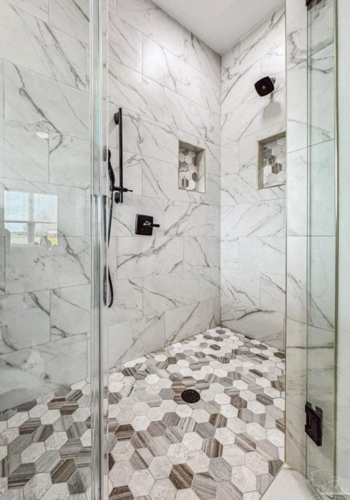Custom tile shower with glass enclosure and rain head